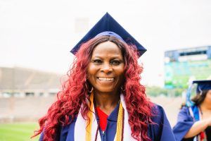 A close-up of Susan Johnson joyfully smiling in her cap and gown at Goodwin’s 2025 commencement ceremony.