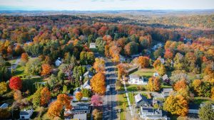 Aerial view of houses and trees with fall foliage.