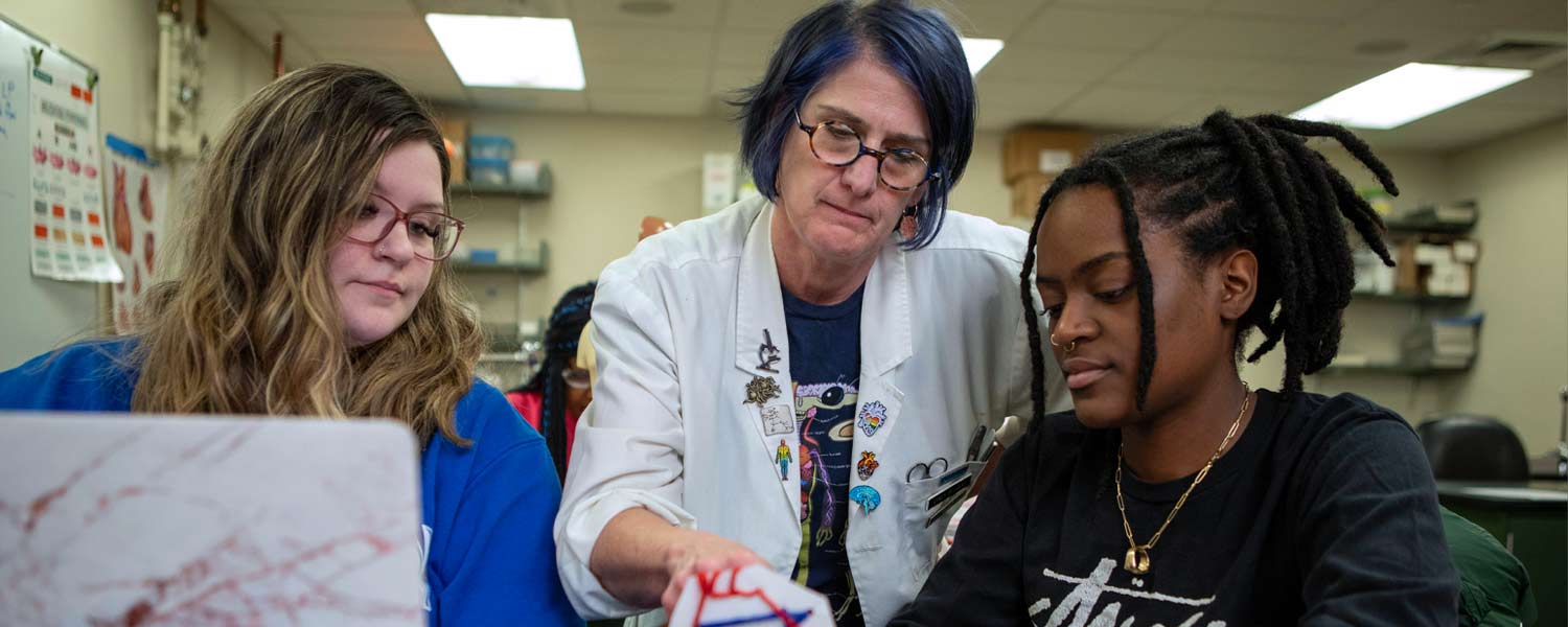 teacher speaking to two students