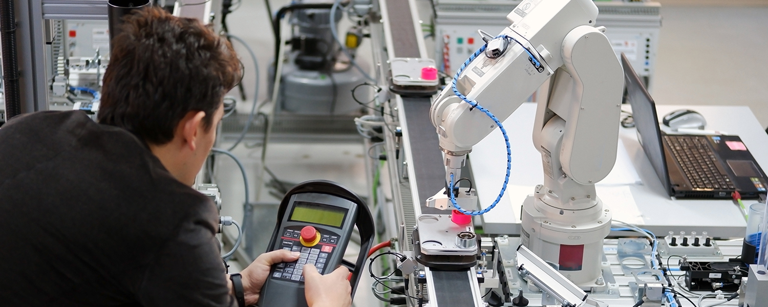 Manufacturing student working with a robotic arm