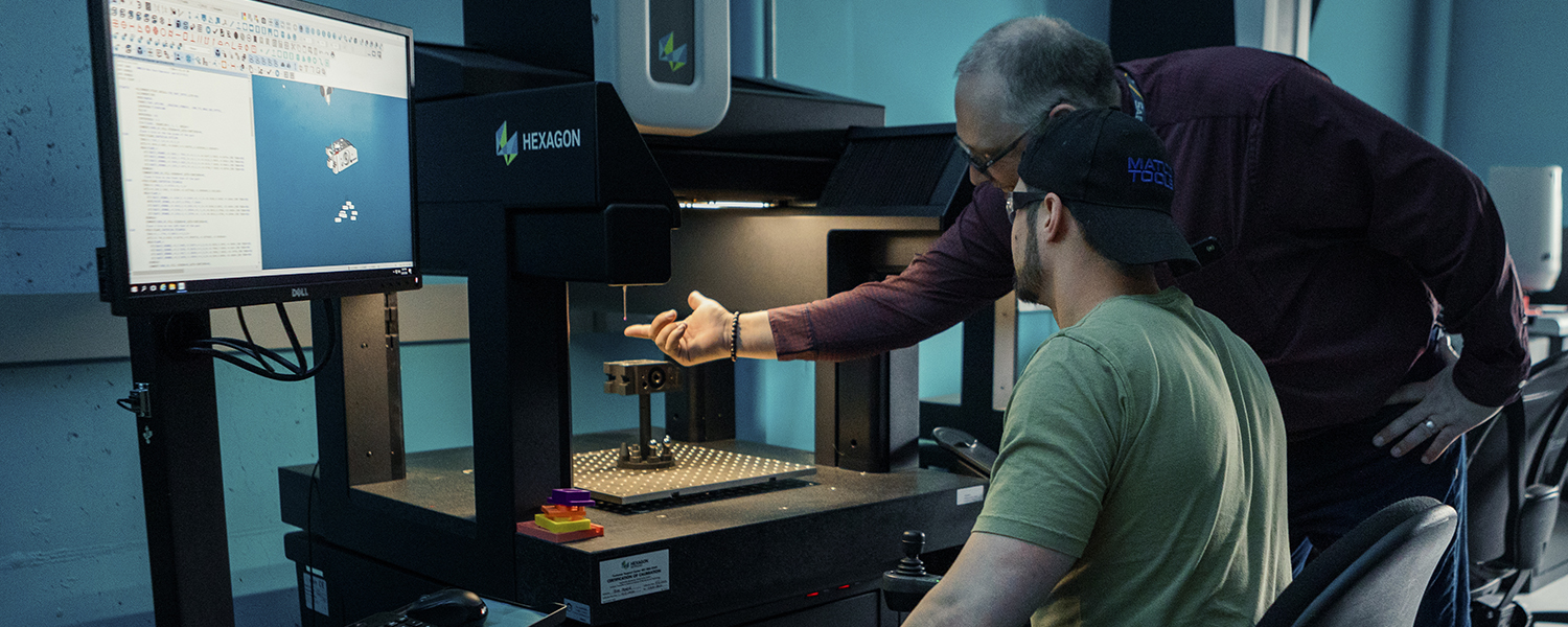 instructor showing MET student how to adjust a 3D printer