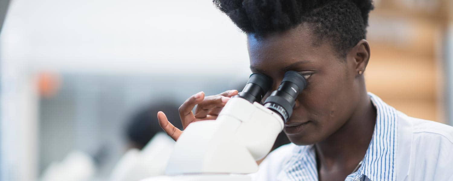 MPH student looking through a microscope